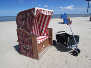 Strandkorb mit Bollerwagen am Strand